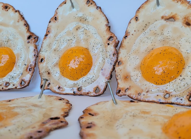 Fried egg hanging on a nail sculpture