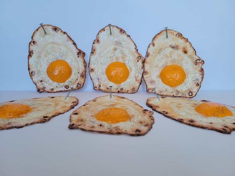 Fried egg hanging on a nail sculpture