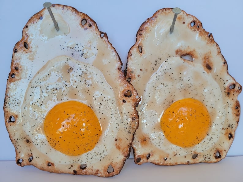 Fried egg hanging on a nail sculpture